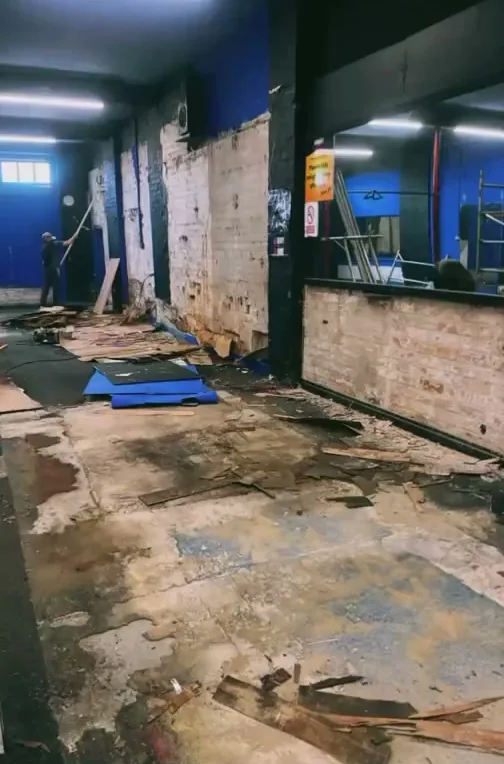 The unit before the build: gutted, floor lifted, bare walls